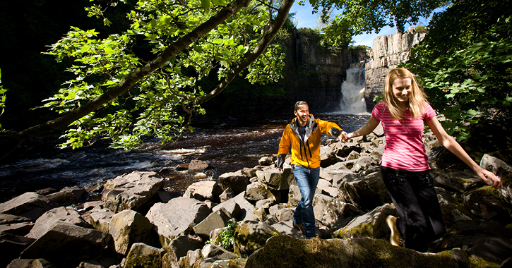 couple walking at High Force Waterfall